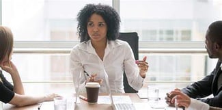 3 people at a table in a discussion 